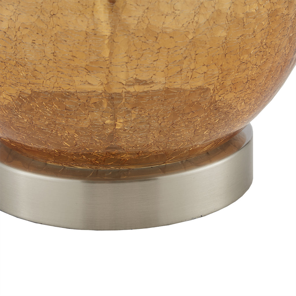 Ombre glass table lamp lit on a bedside table